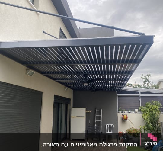 פרגולה מאלומיניום מותקנת מעל מרפסת חיצונית